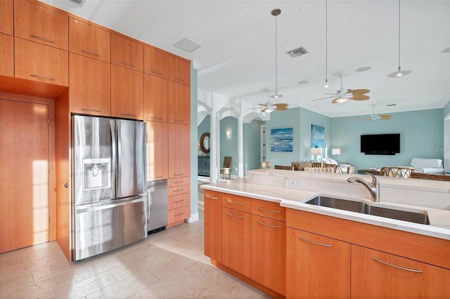 kitchen featuring stainless steel fridge, sink, ceiling fan, and pendant lighting