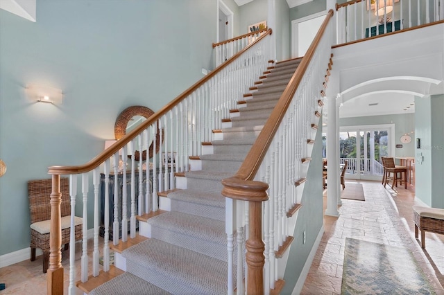 stairway featuring a towering ceiling