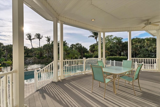 deck with a water view and ceiling fan