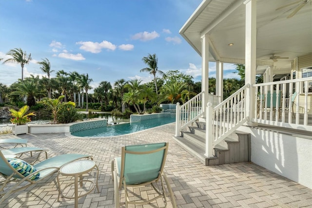 view of swimming pool featuring a patio, a water view, pool water feature, and ceiling fan