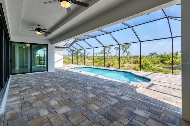 view of pool featuring a patio, glass enclosure, and ceiling fan