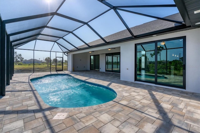 view of pool featuring glass enclosure and a patio