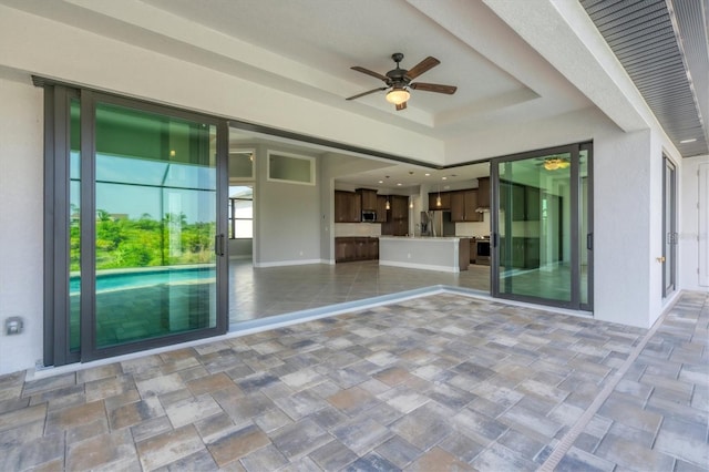 unfurnished room with tile flooring, ceiling fan, and a raised ceiling