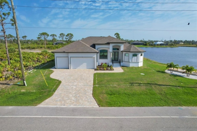 view of front of property featuring a water view, a garage, and a front yard