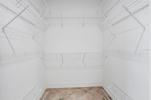 walk in closet with tile floors