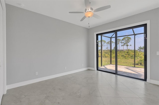 empty room featuring ceiling fan, light tile flooring, and a wealth of natural light