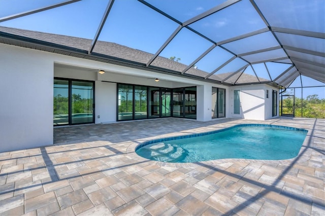 view of pool featuring a patio area, ceiling fan, and glass enclosure