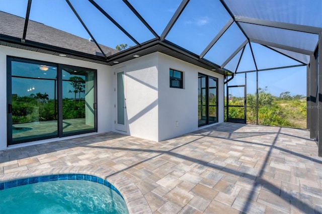 view of pool featuring glass enclosure and a patio