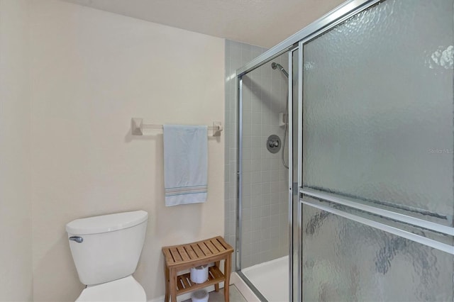 bathroom featuring toilet and an enclosed shower