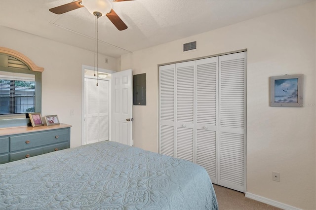 bedroom with electric panel, ceiling fan, a closet, and light carpet