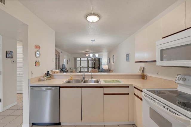 kitchen featuring a textured ceiling, white appliances, ceiling fan, sink, and light tile patterned floors