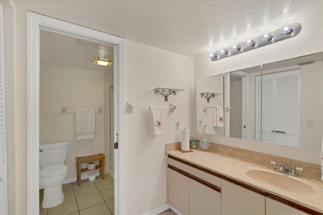 bathroom with tile patterned floors, vanity, a textured ceiling, and toilet