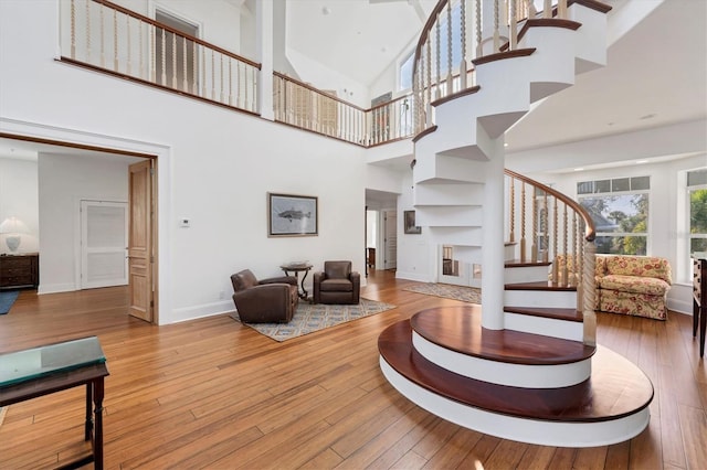 living room with a towering ceiling and light wood-type flooring