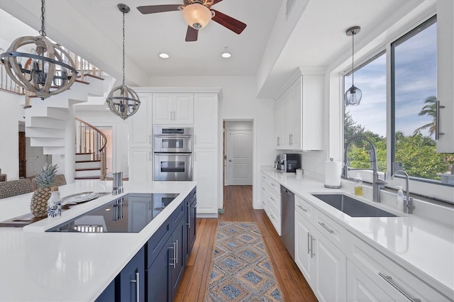 kitchen featuring white cabinets, appliances with stainless steel finishes, a wealth of natural light, and dark wood-type flooring