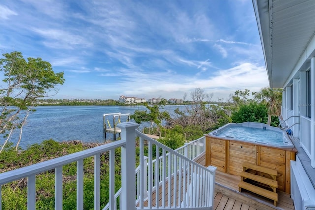 balcony with a water view and a hot tub