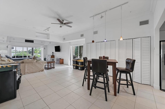 dining area featuring ceiling fan, light tile patterned floors, and crown molding