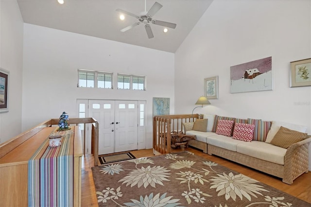 living room with wood-type flooring, high vaulted ceiling, and ceiling fan