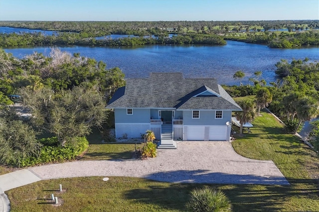 view of front of property with a water view, a garage, and a front lawn