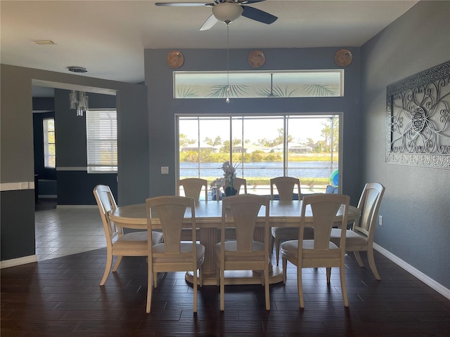 dining space with ceiling fan and dark hardwood / wood-style flooring