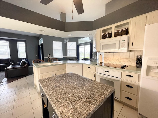 kitchen with a center island, light tile patterned floors, white appliances, and sink