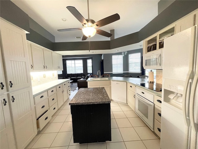 kitchen featuring a center island, white appliances, sink, and light tile patterned floors