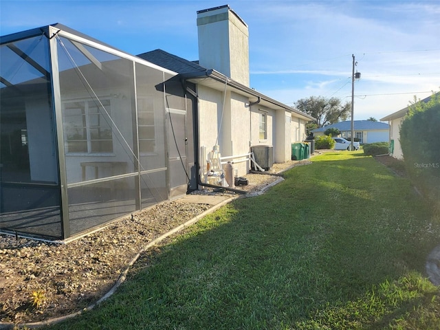 view of property exterior with a lawn and glass enclosure