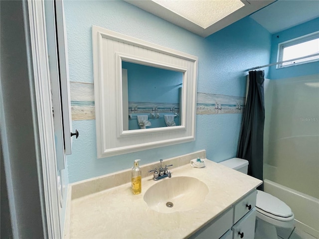 full bathroom featuring vanity, shower / bath combination with curtain, toilet, and a textured ceiling