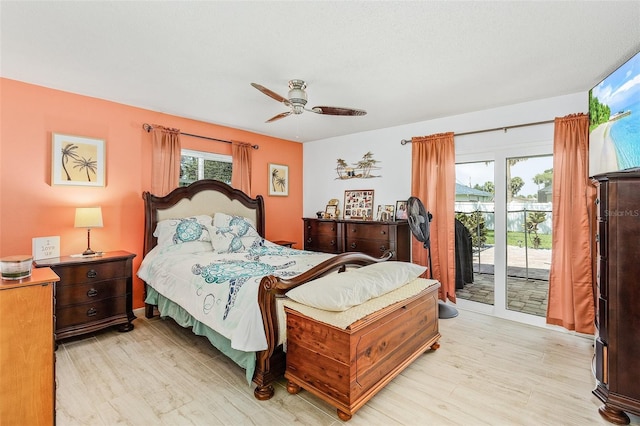 bedroom featuring multiple windows, access to outside, and light hardwood / wood-style floors