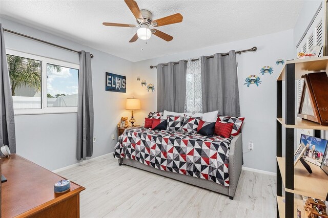 bedroom featuring ceiling fan, a textured ceiling, and light wood-type flooring