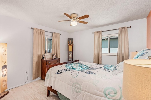 bedroom with ceiling fan, wood-type flooring, and a textured ceiling