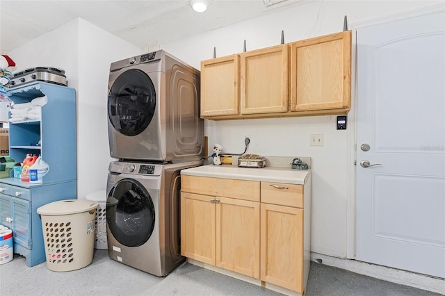 washroom featuring cabinets and stacked washer / drying machine