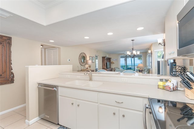 kitchen with a chandelier, stainless steel appliances, white cabinetry, and sink