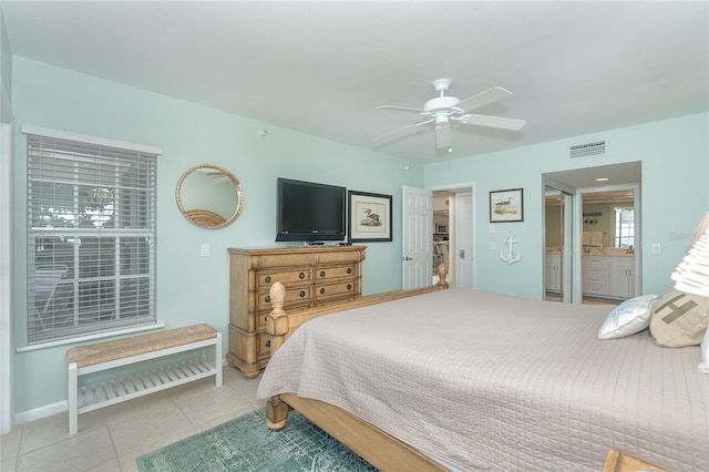 bedroom featuring ceiling fan, light tile patterned floors, and ensuite bathroom