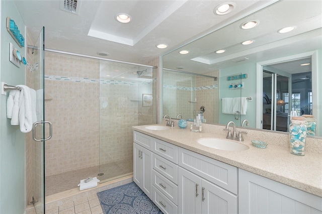 bathroom featuring tile patterned floors, a tray ceiling, vanity, and walk in shower