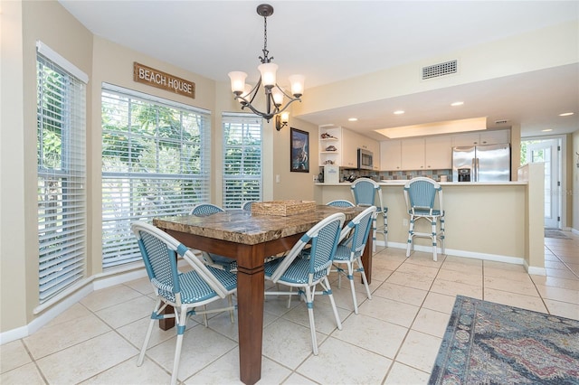 tiled dining space featuring a chandelier