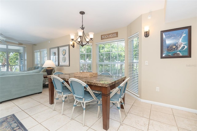 tiled dining area with ceiling fan with notable chandelier and a wealth of natural light