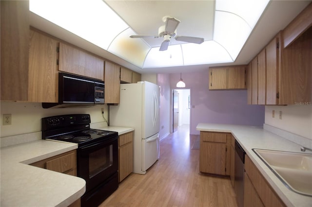 kitchen featuring black appliances, ceiling fan, sink, and light hardwood / wood-style flooring