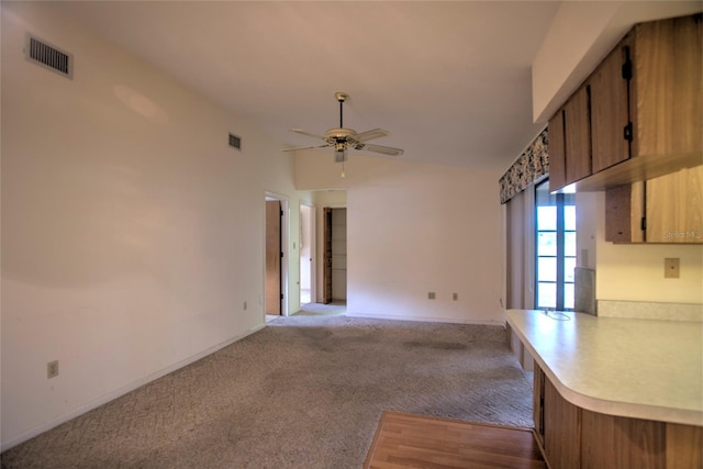 unfurnished living room with ceiling fan, light carpet, and vaulted ceiling