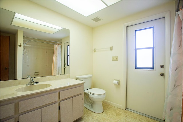 bathroom featuring a shower with shower curtain, vanity, and toilet