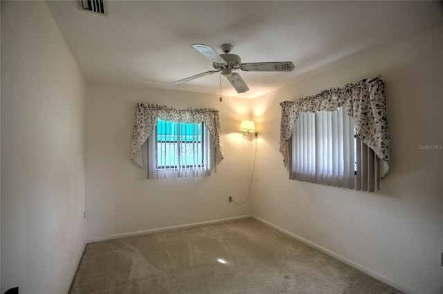 unfurnished room featuring ceiling fan and carpet