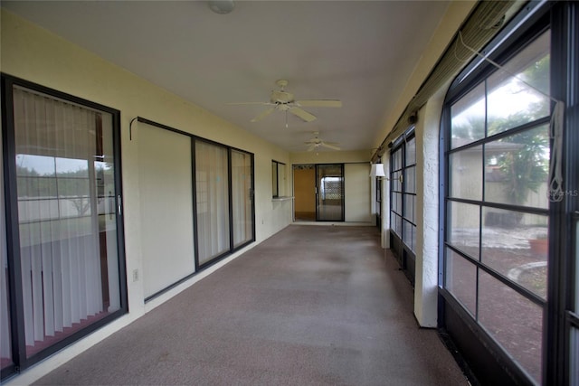 unfurnished sunroom with ceiling fan