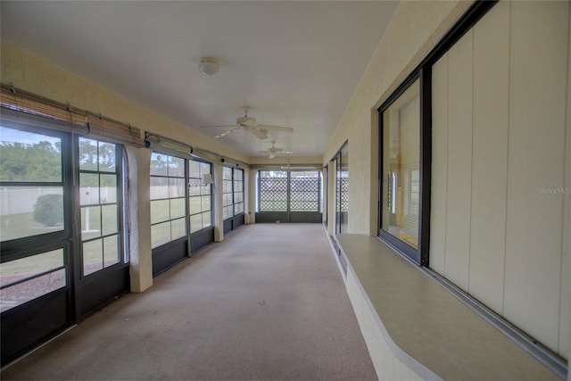 unfurnished sunroom featuring ceiling fan