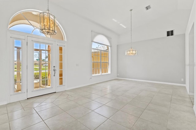 foyer entrance with light tile patterned floors and an inviting chandelier