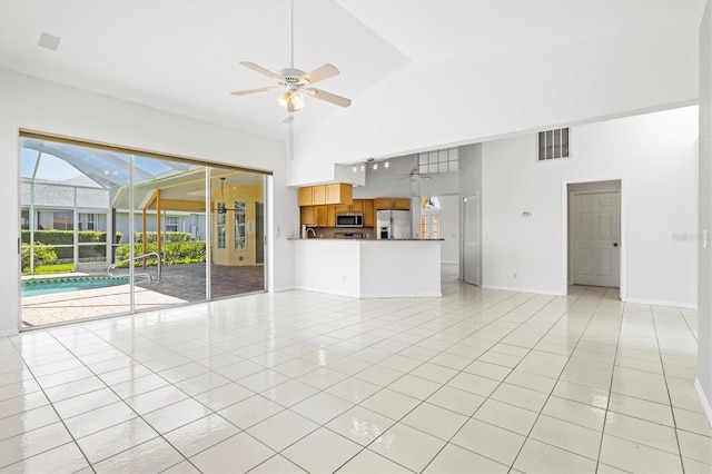 unfurnished living room featuring light tile patterned floors, high vaulted ceiling, and ceiling fan