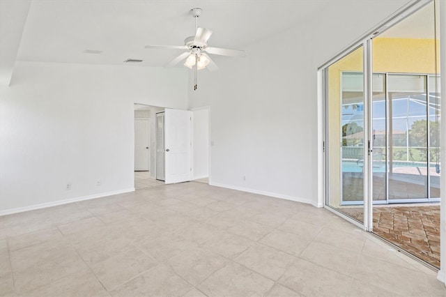 spare room featuring ceiling fan, lofted ceiling, and light tile patterned floors