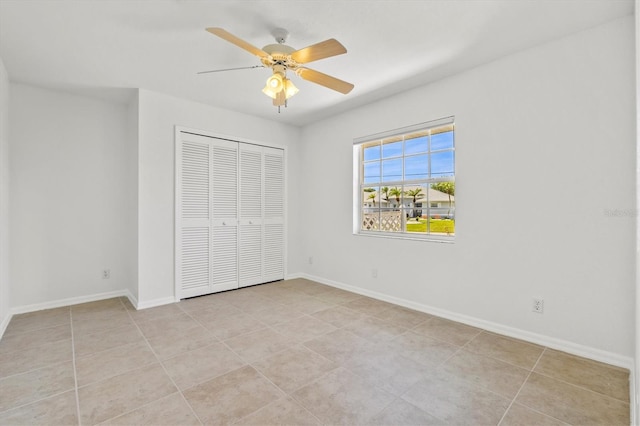 unfurnished bedroom with ceiling fan, a closet, and light tile patterned floors