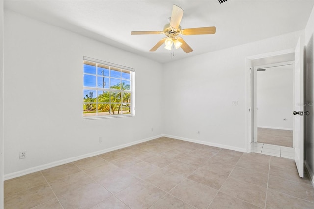 spare room with ceiling fan and light tile patterned floors