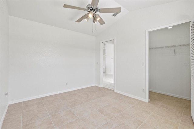 unfurnished bedroom featuring light tile patterned floors, a closet, vaulted ceiling, and ceiling fan