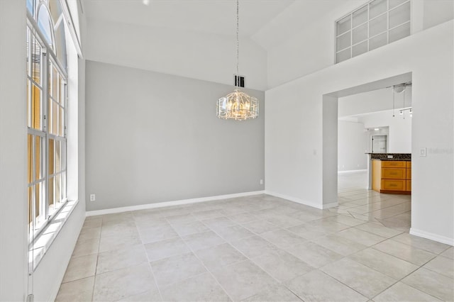 tiled empty room with high vaulted ceiling and a notable chandelier