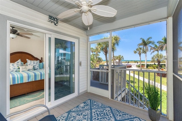 sunroom with ceiling fan and wooden ceiling